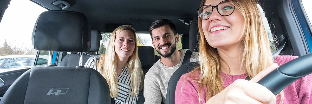 Ein paar sitzt auf der Rückbank im Auto einer Fahrerin