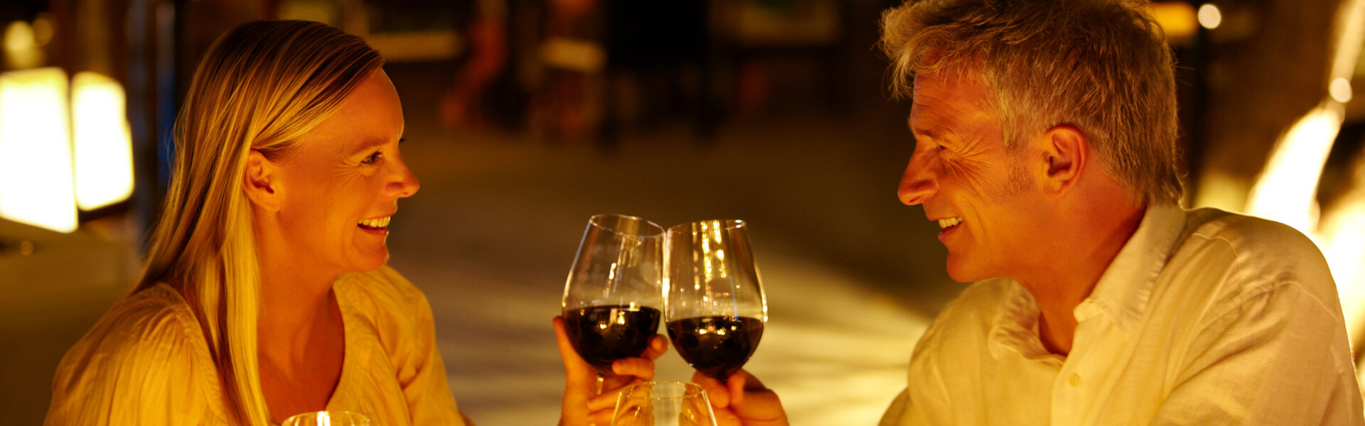 Ein Paar beim romantischen Dinner stößt mit Rotwein an
